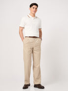 man wearing a classic white polo t-shirt with jacquard collar and beige trouser
