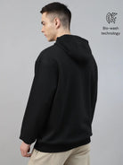 Person wearing a black hoodie made with 'Bio-wash fabric'