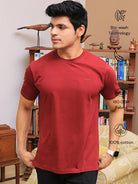 Man wearing a crew neck red cotton t-shirt, standing in a room