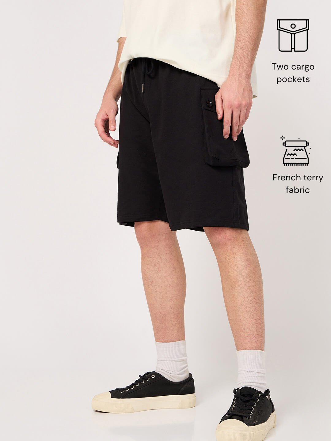 Person wearing black shorts with two cargo pockets on a white background