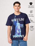 Person wearing a navy blue t-shirt with a printed graphic design and text