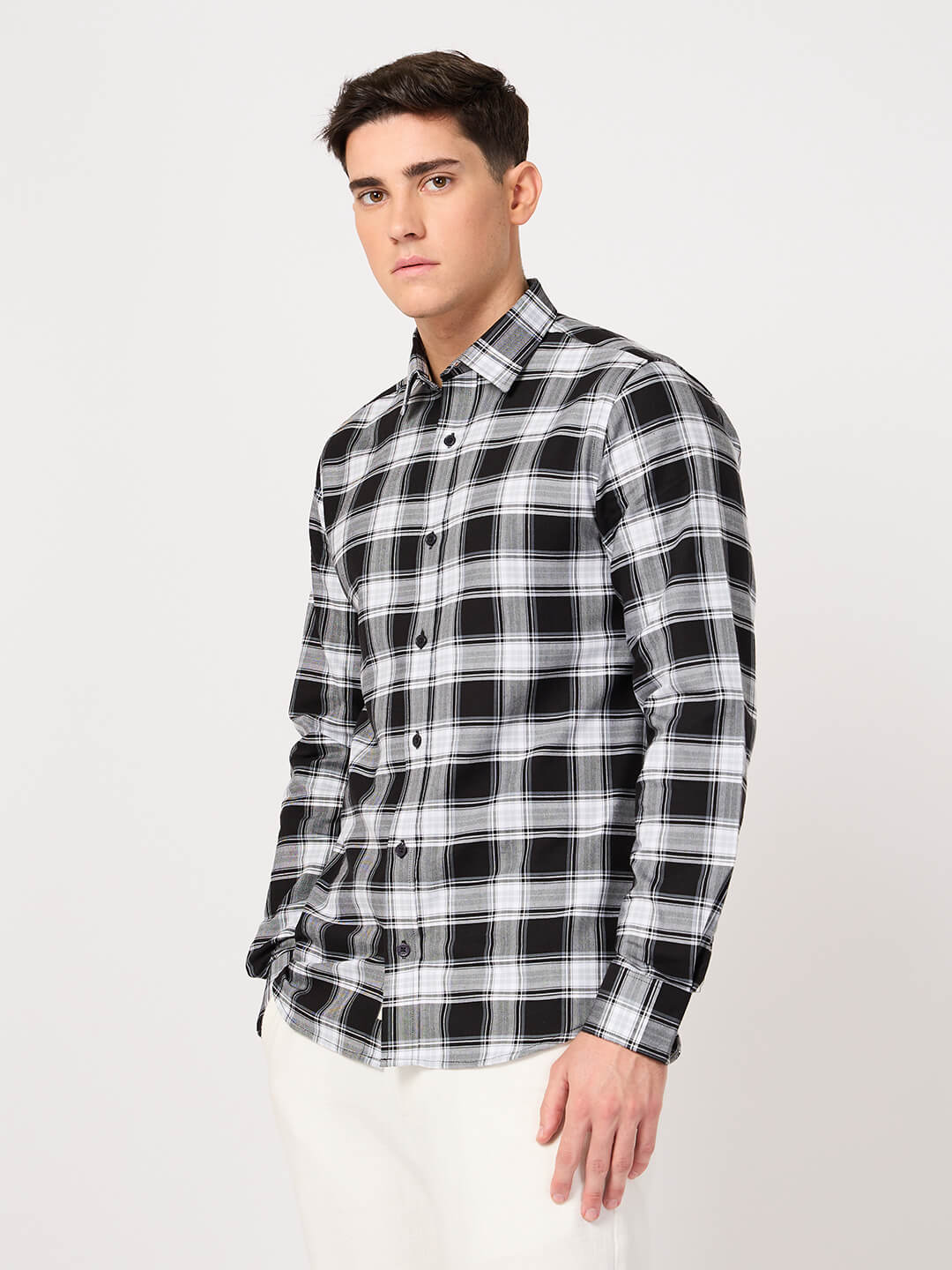 Man wearing a cotton black and white check shirt on a white background
