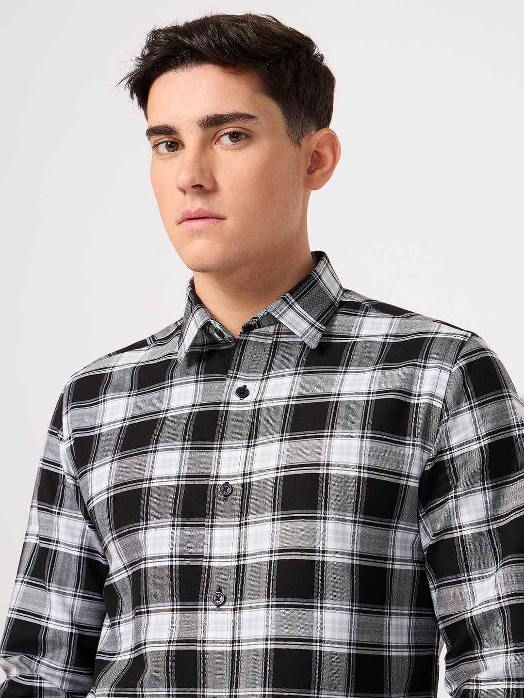 Man wearing a black and white plaid shirt made with pure cotton