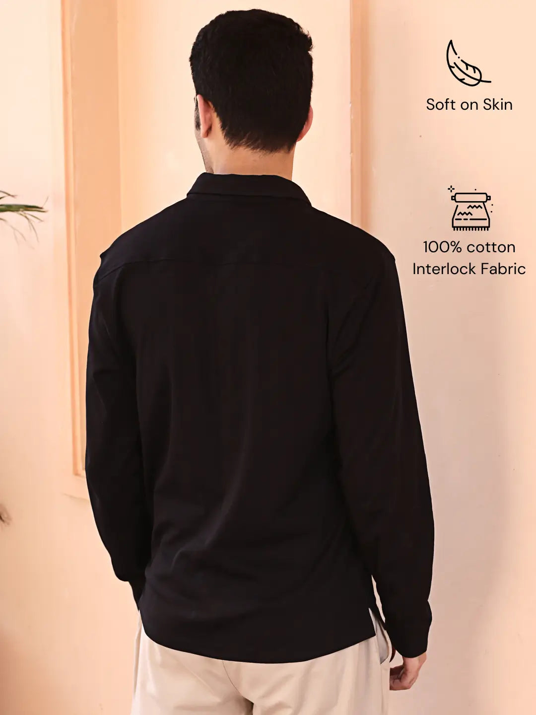 Man wearing a black cotton shirt with text indicating soft on skin and 100% cotton interlock fabric.