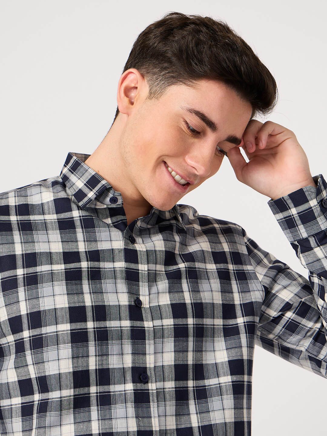 Man wearing a plaid shirt against a plain background