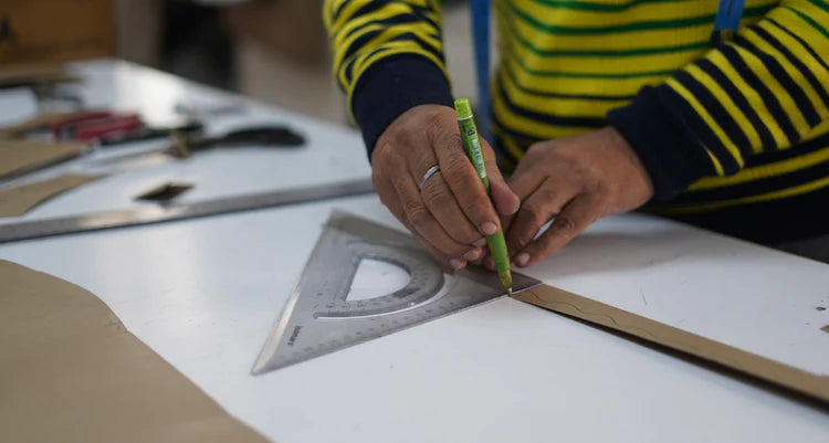 person taking mark on paper strip with the help of scale