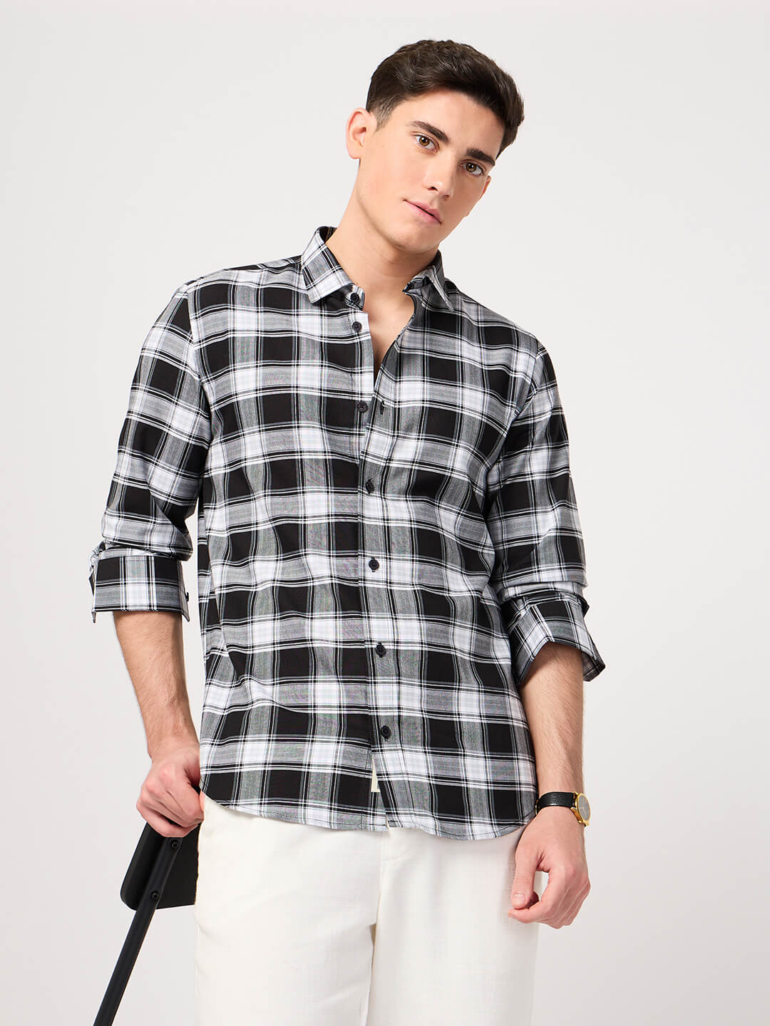 Man wearing a black and white plaid shirt on a plain background
