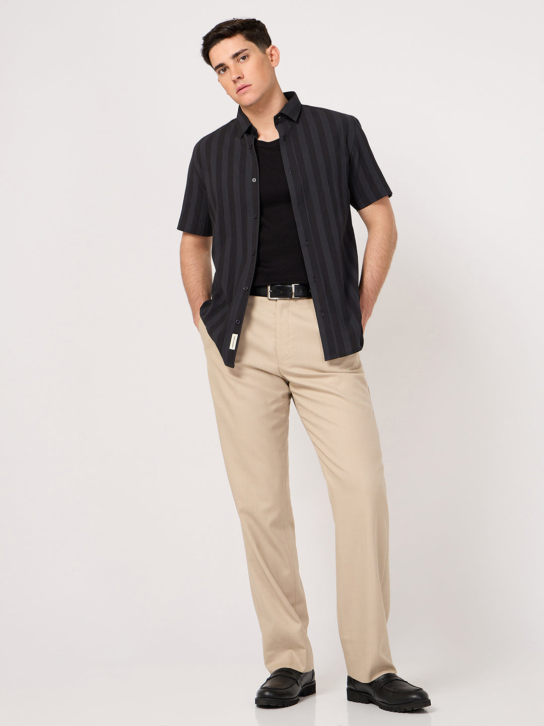 A man wearing a striped half sleeve shirt with beige trouser