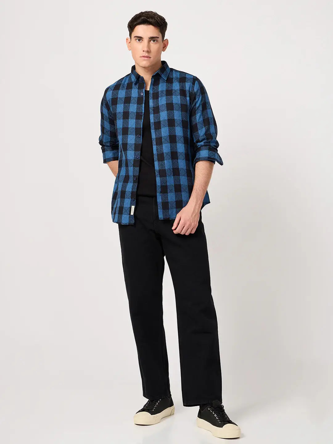 Man wearing a blue and black checkered shirt with black pants