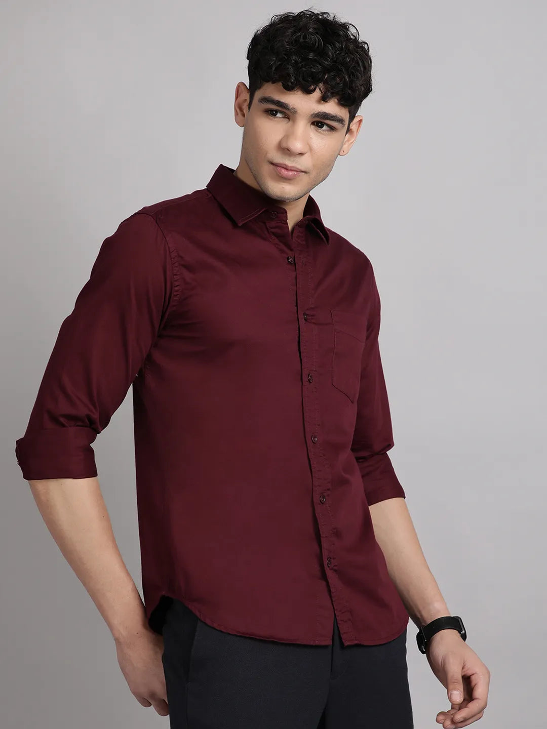 Man wearing a maroon shirt against a gray background