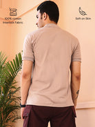 Man wearing a beige polo shirt made with cotton fabric, softness on skin.