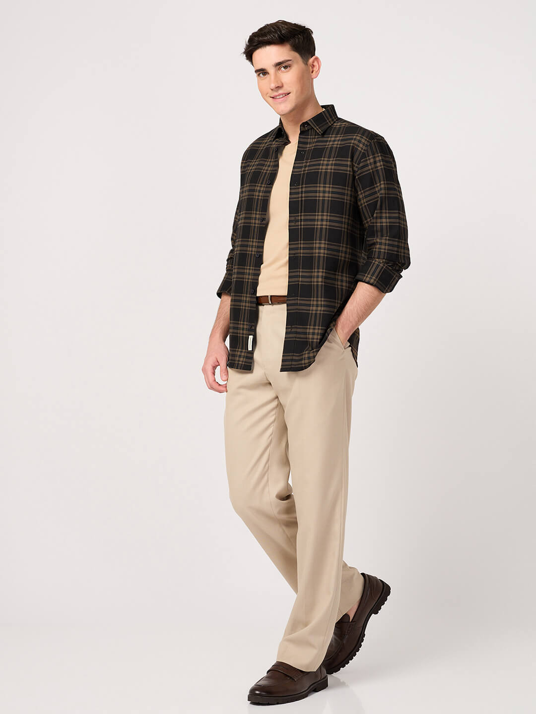Man wearing a Oxford Cotton Brown Check Shirt, and beige pants on a white background