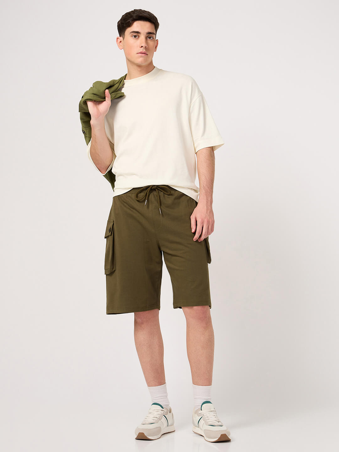Man wearing a white t-shirt and olive cargo shorts on a white background