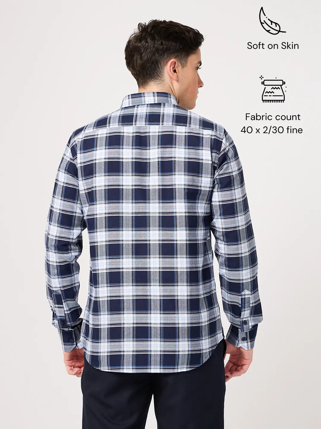 Man wearing a blue and white checkered shirt with fabric details on a white background