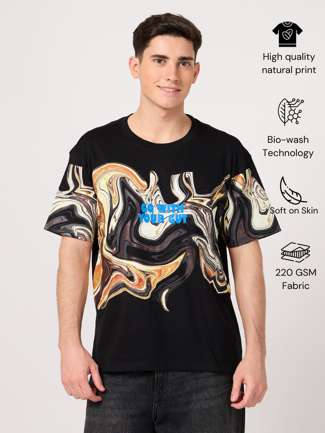 Man wearing a black t-shirt with printed abstract design on a light gray background.