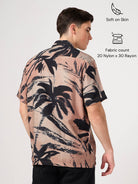 Man wearing a patterned resort shirt with palm tree design