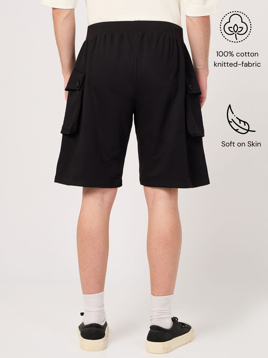 Person wearing black cargo shorts on a white background