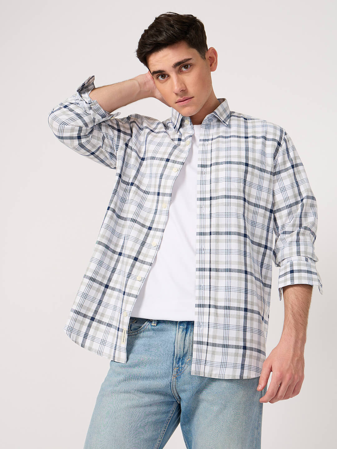 Man wearing a cotton check shirt over a white tshirt with light blue jeans