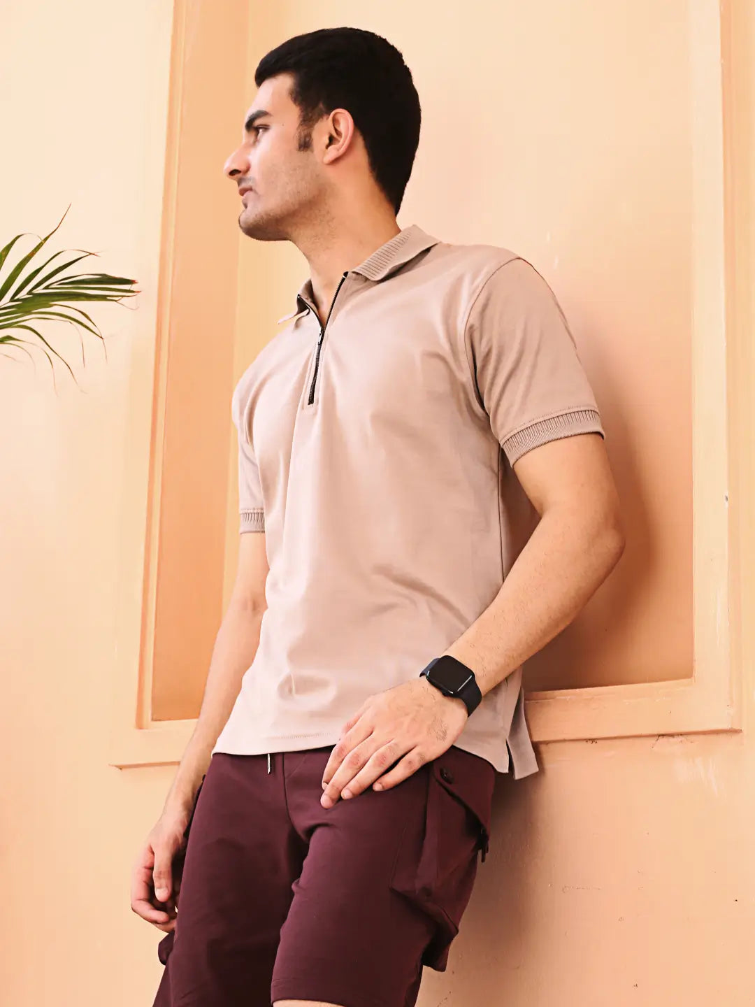 Man wearing a beige polo shirt and maroon shorts