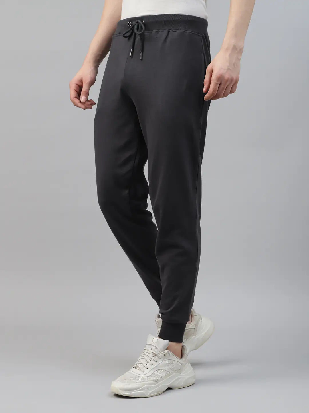 Person wearing black jogger pants and white sneakers