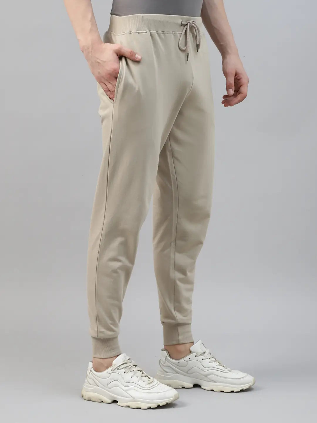 Person wearing beige jogger pants and white sneakers