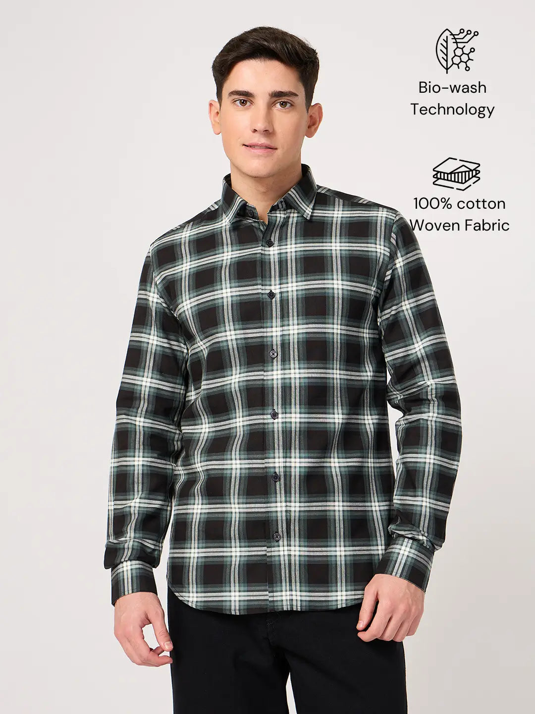 Man wearing a black and green plaid shirt made with pure cotton fabric