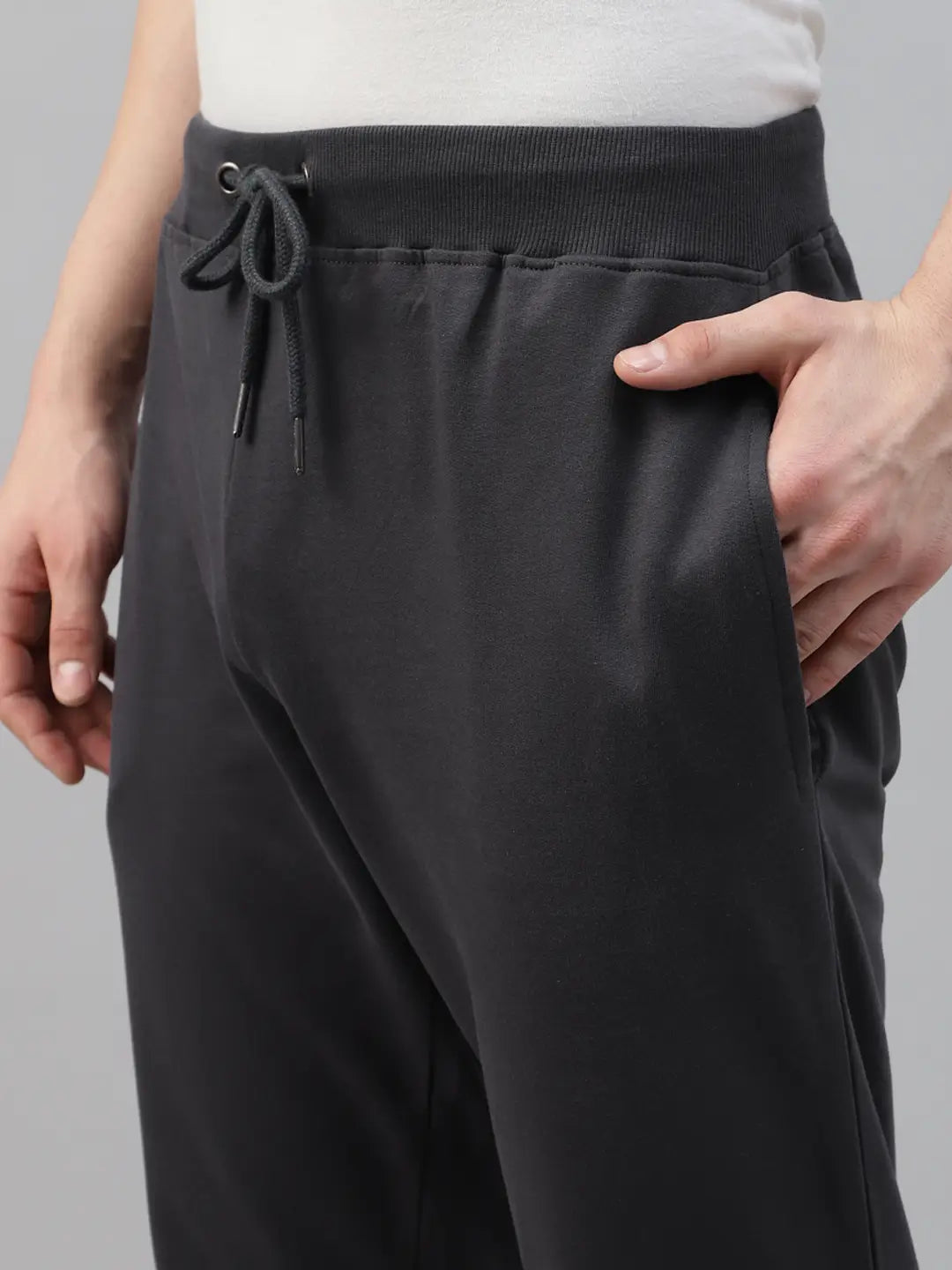 Person wearing dark grey jogger pants with a drawstring