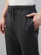 Person wearing dark grey jogger pants with a drawstring