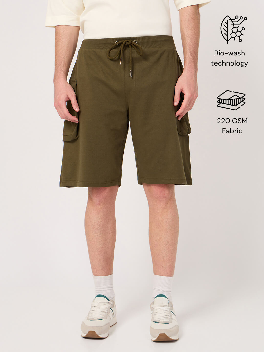 Person wearing olive green shorts on a white background