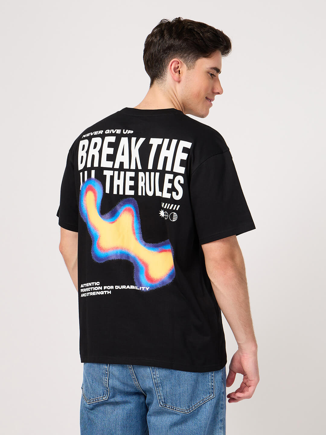 Person wearing a black t-shirt with colorful design and text on the back