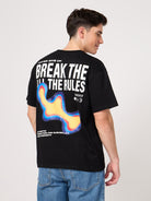 Person wearing a black t-shirt with colorful design and text on the back