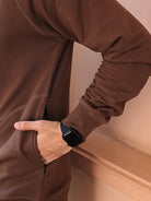 Person wearing a brown long-sleeve sweatshirt