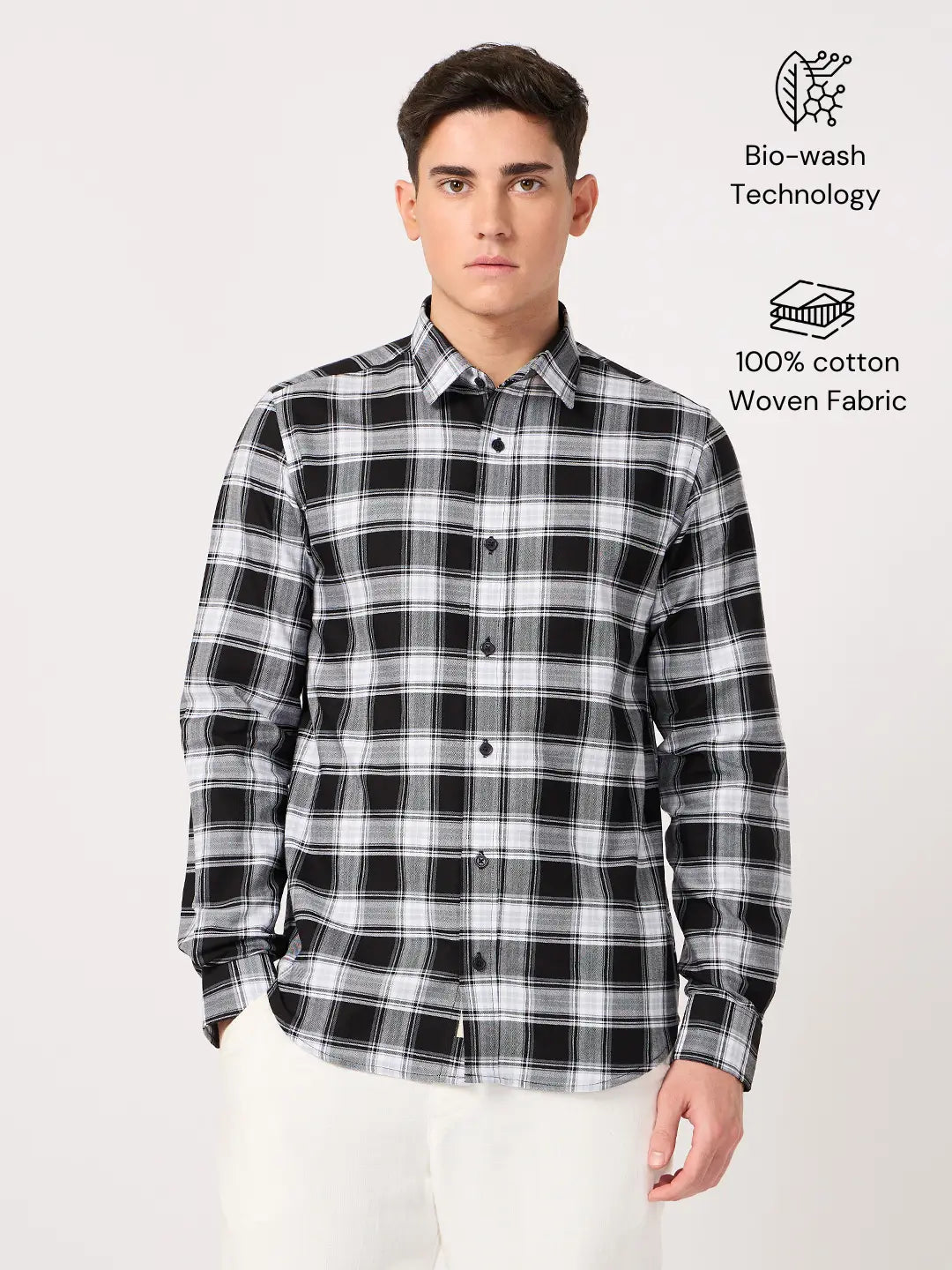 Man wearing a black and white plaid shirt with text about bio-wash technology and 100% cotton fabric on a white background.
