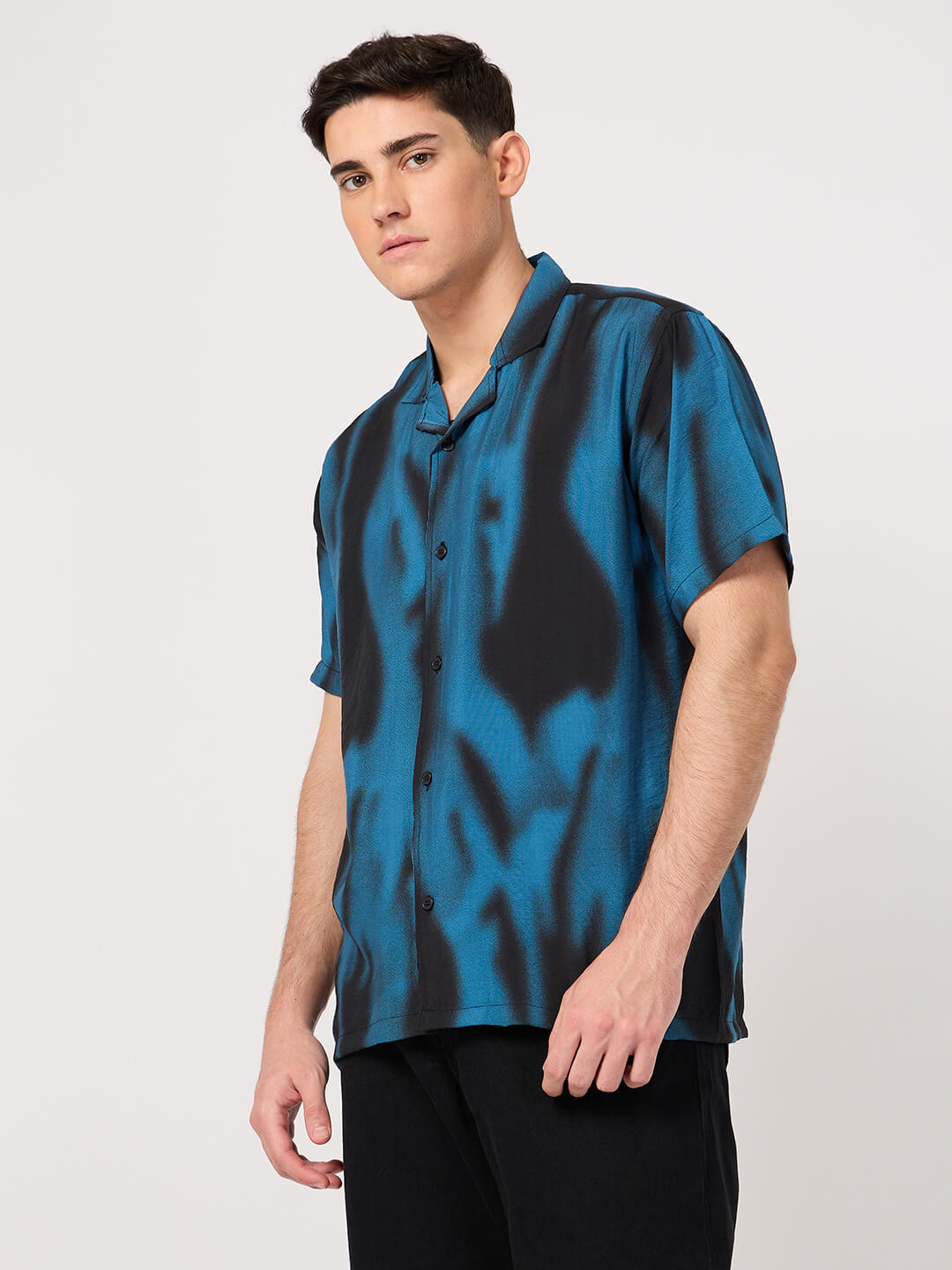 A man wearing a stylish blue and black resort shirt with short sleeves