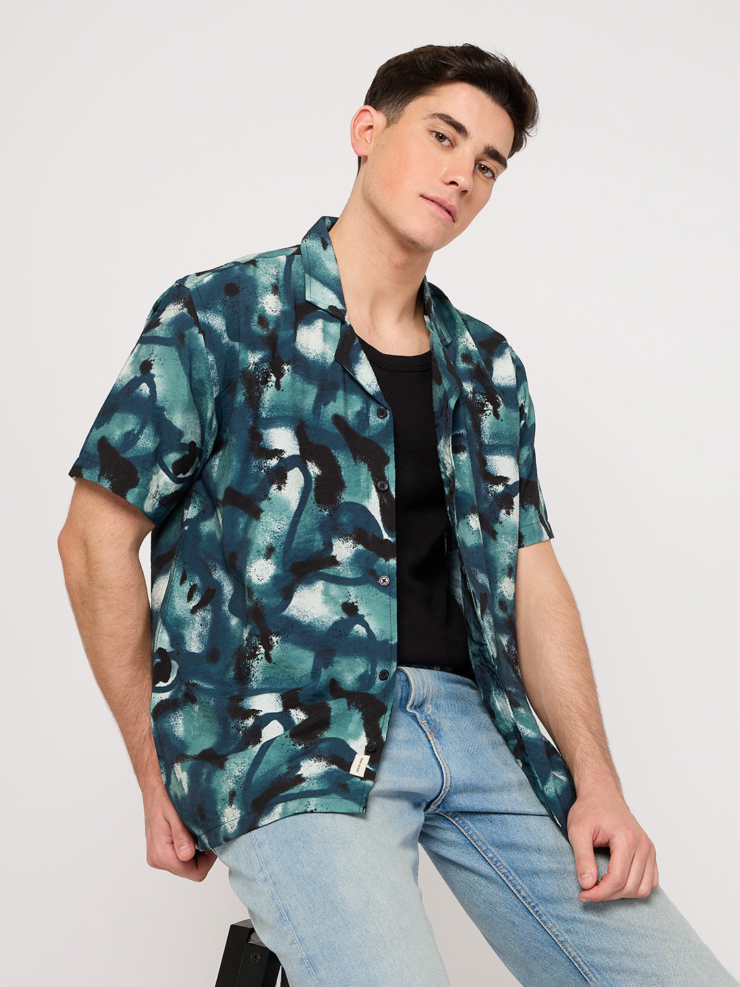 men wearing a black round neck tee and layring a blue print resort shirt by thrust club