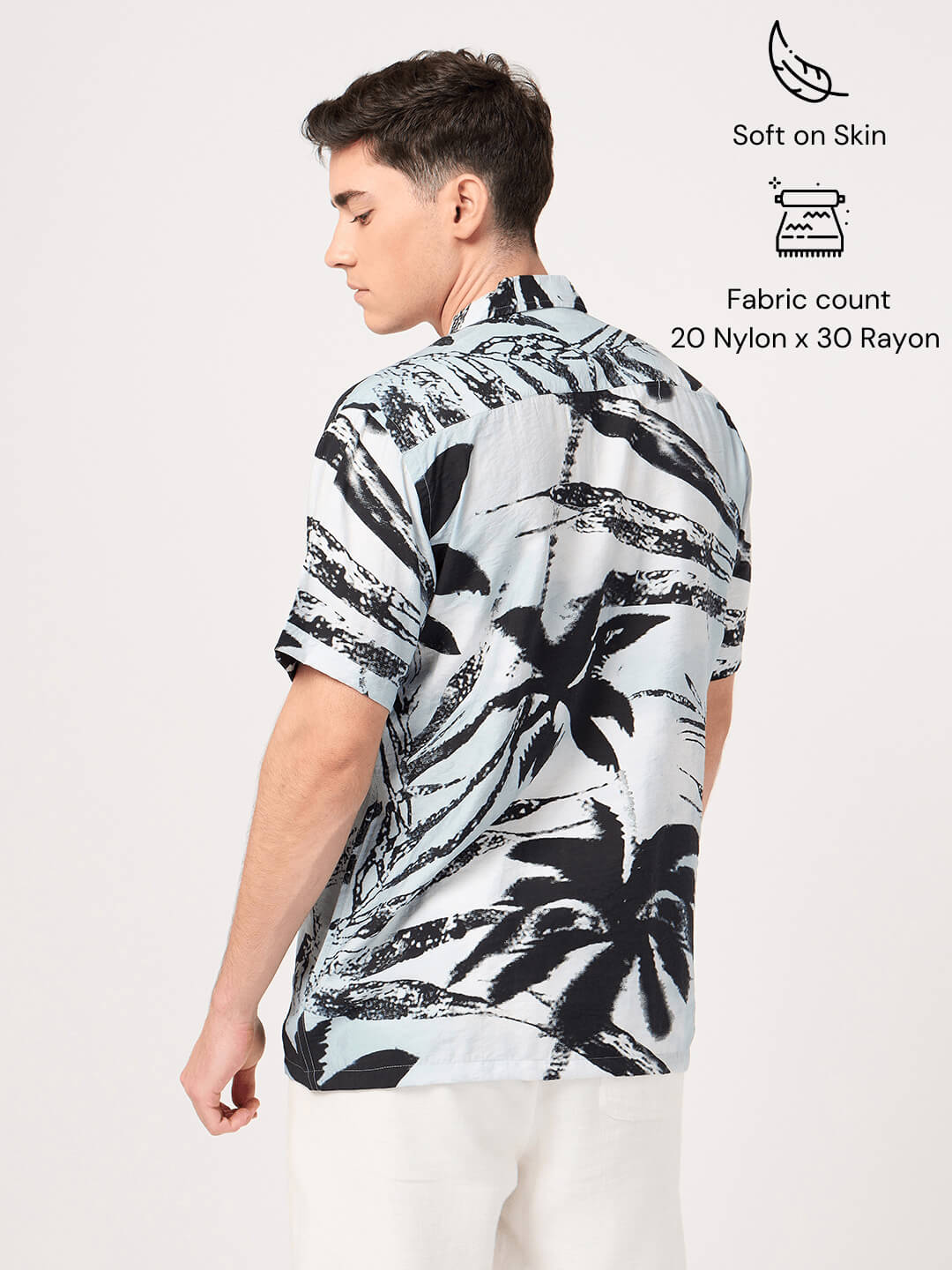 Man wearing a black and white patterned shirt on a white background