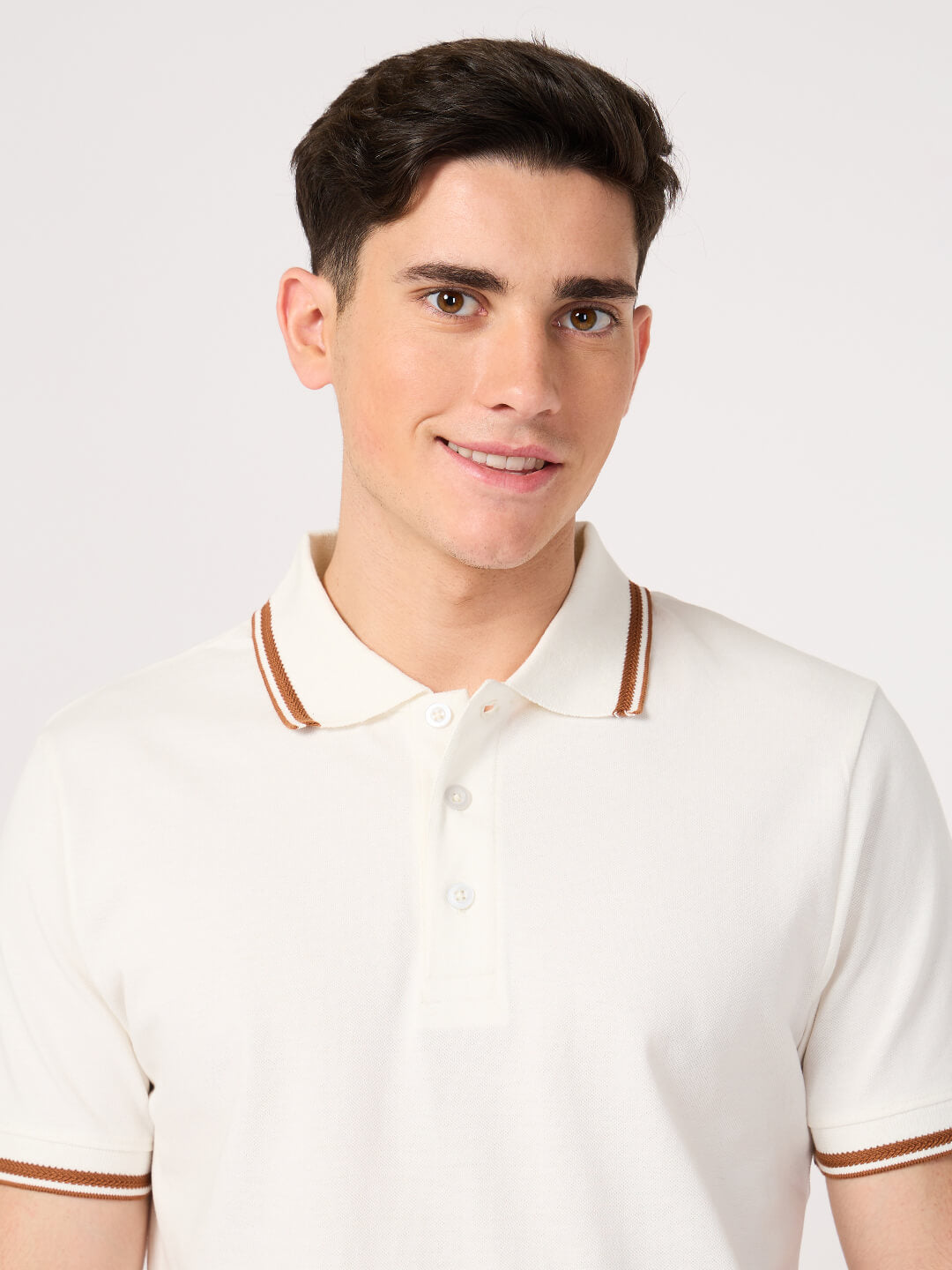 man wearing a classic white polo t-shirt with jacquard collar made with cotton pique fabric