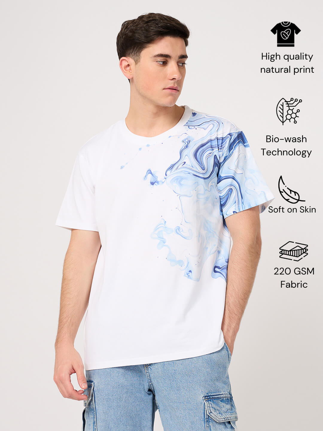 Person wearing a white t-shirt with blue abstract design on a light gray background