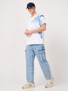 man wearing a thrust club's white printed tshirt and jeans