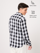 A man wearing a black and white checked shirt with full sleeves.