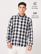 A man wearing a black and white checked shirt with full sleeves.