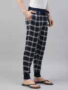Person wearing black and white plaid jogger pants on a gray background