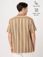 Man wearing a brown and beige striped shirt on a white background