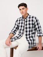 A man wearing a black and white checked shirt with full sleeve, crafted from croatia fabric