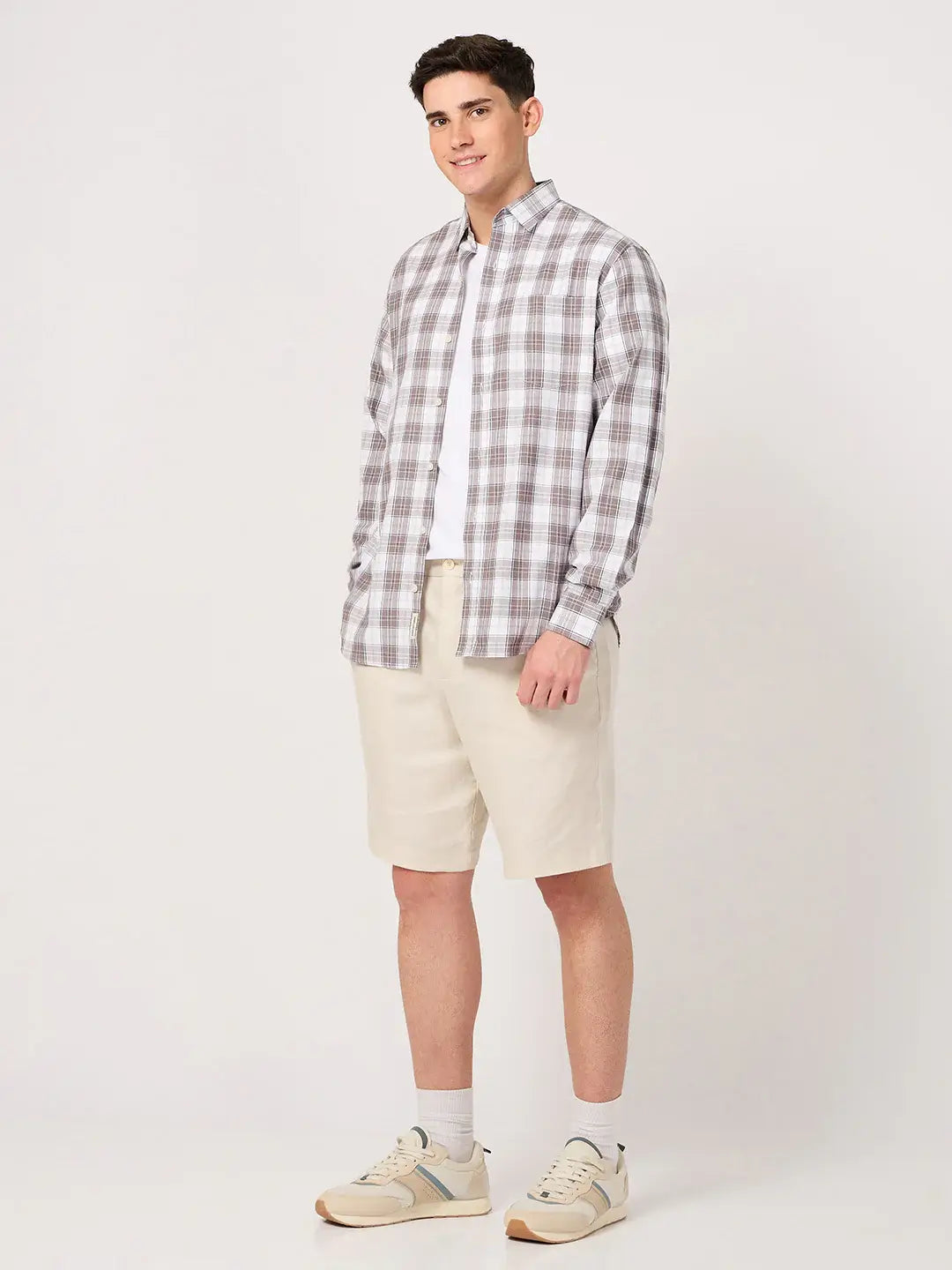 Man wearing a brown and white check shirt and beige shorts