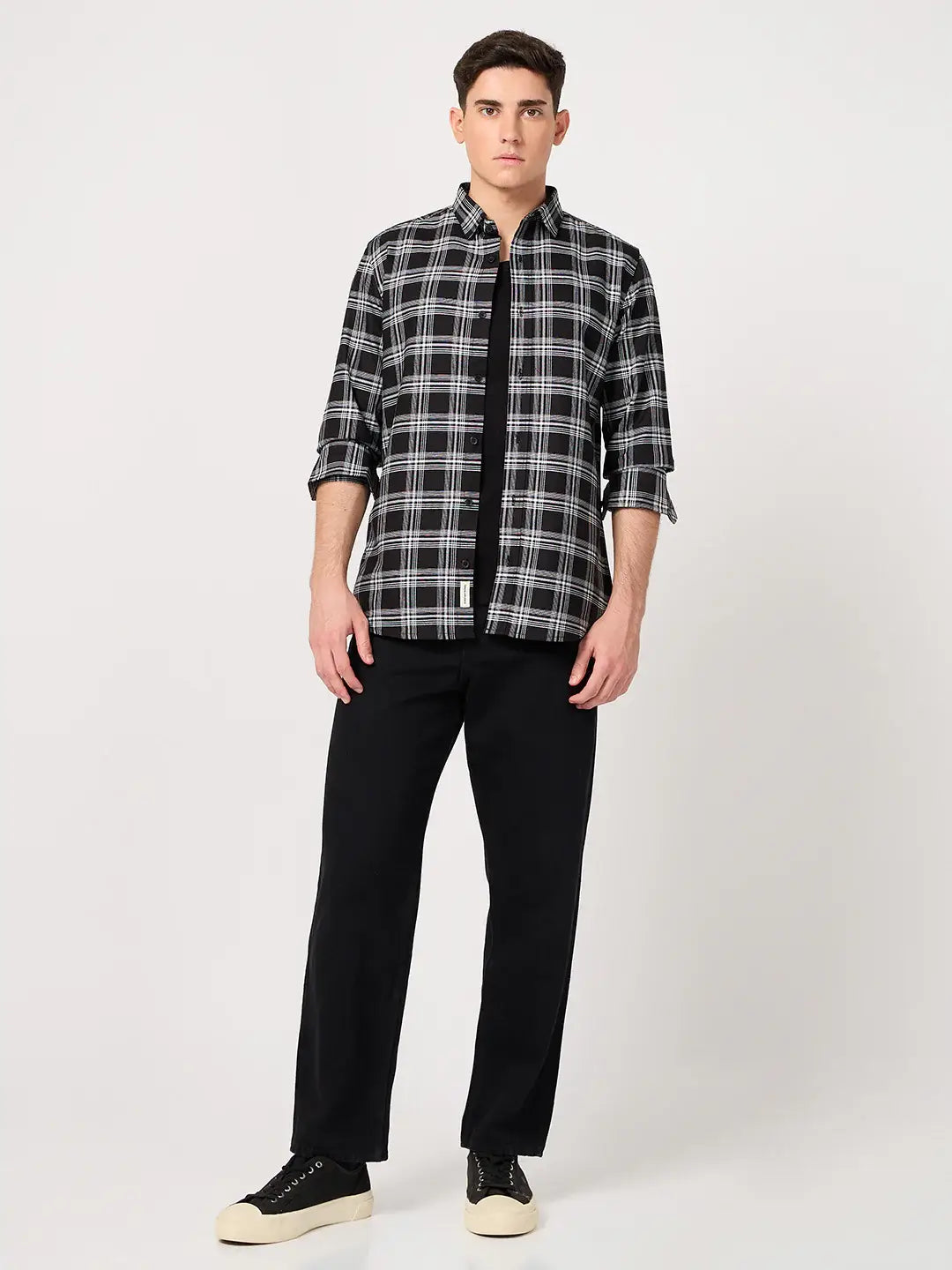 Man wearing a black and white checkered shirt and black pants
