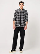 Man wearing a black and white checkered shirt and black pants