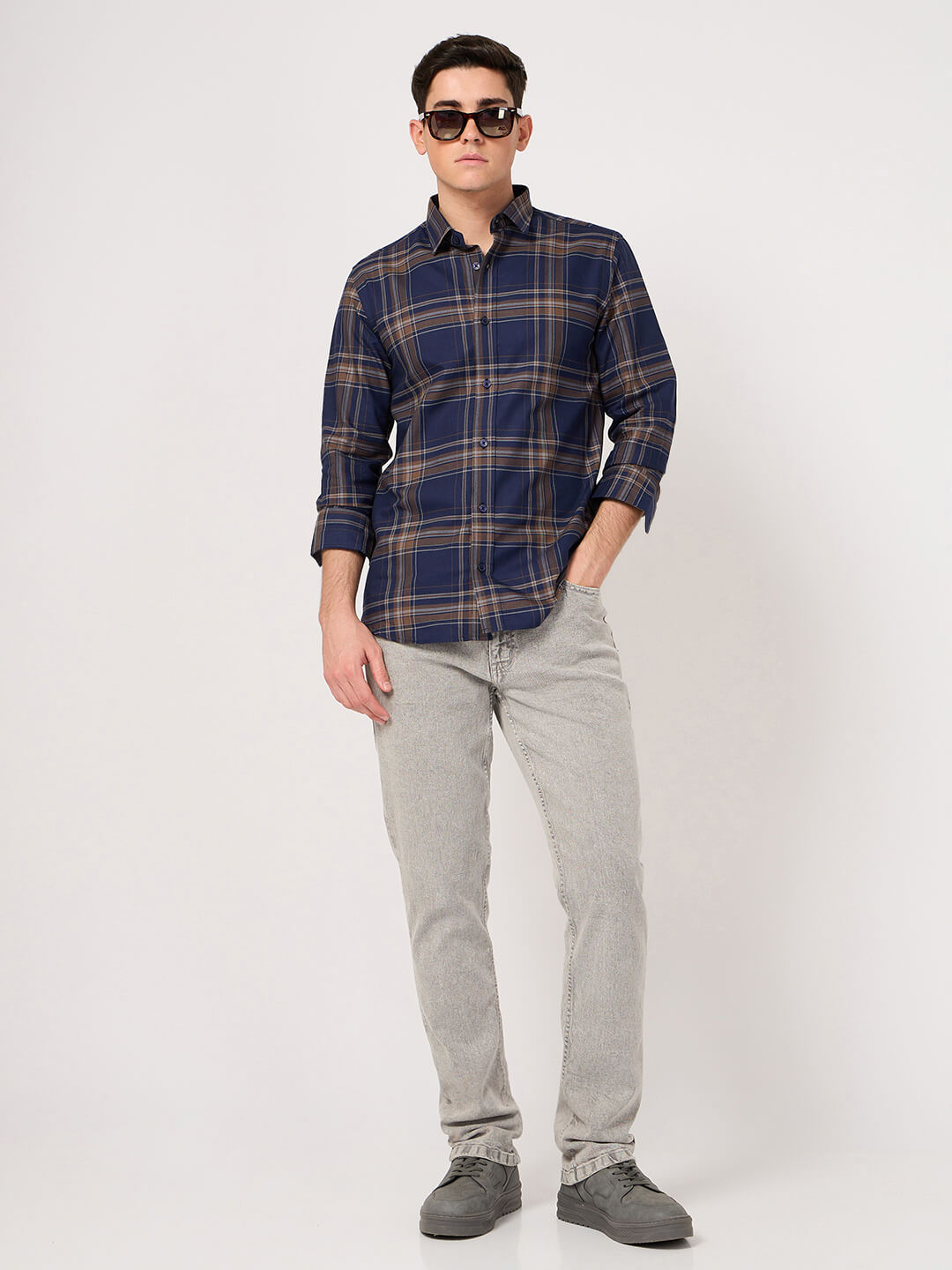 Man wearing blue brown check shirt shirt and gray pants
