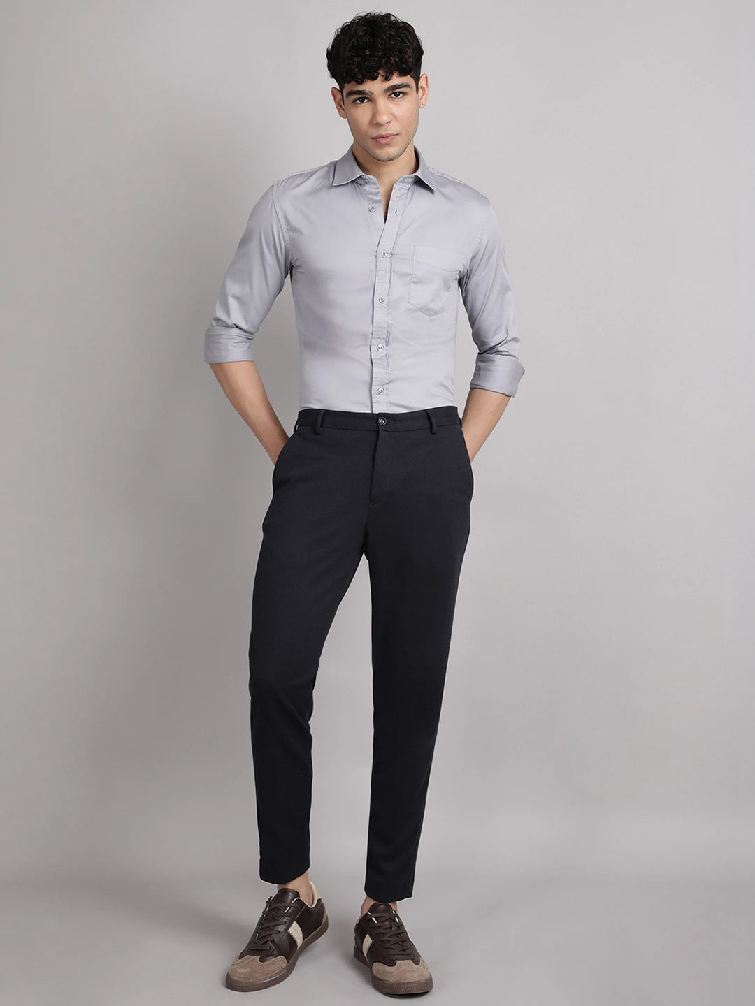 Man wearing a light gray shirt and black pants