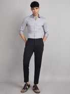 Man wearing a light gray shirt and black pants